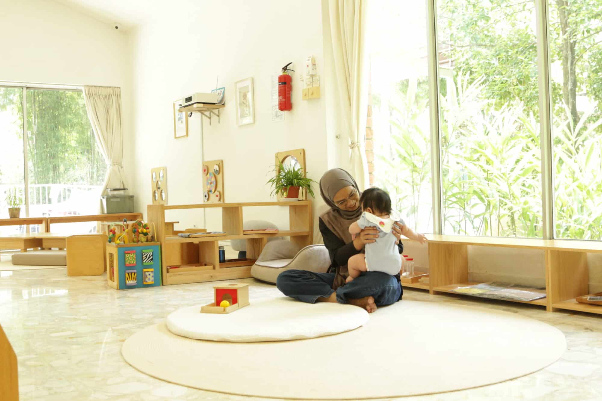 Teacher taking care of an infant in a montessori classroom