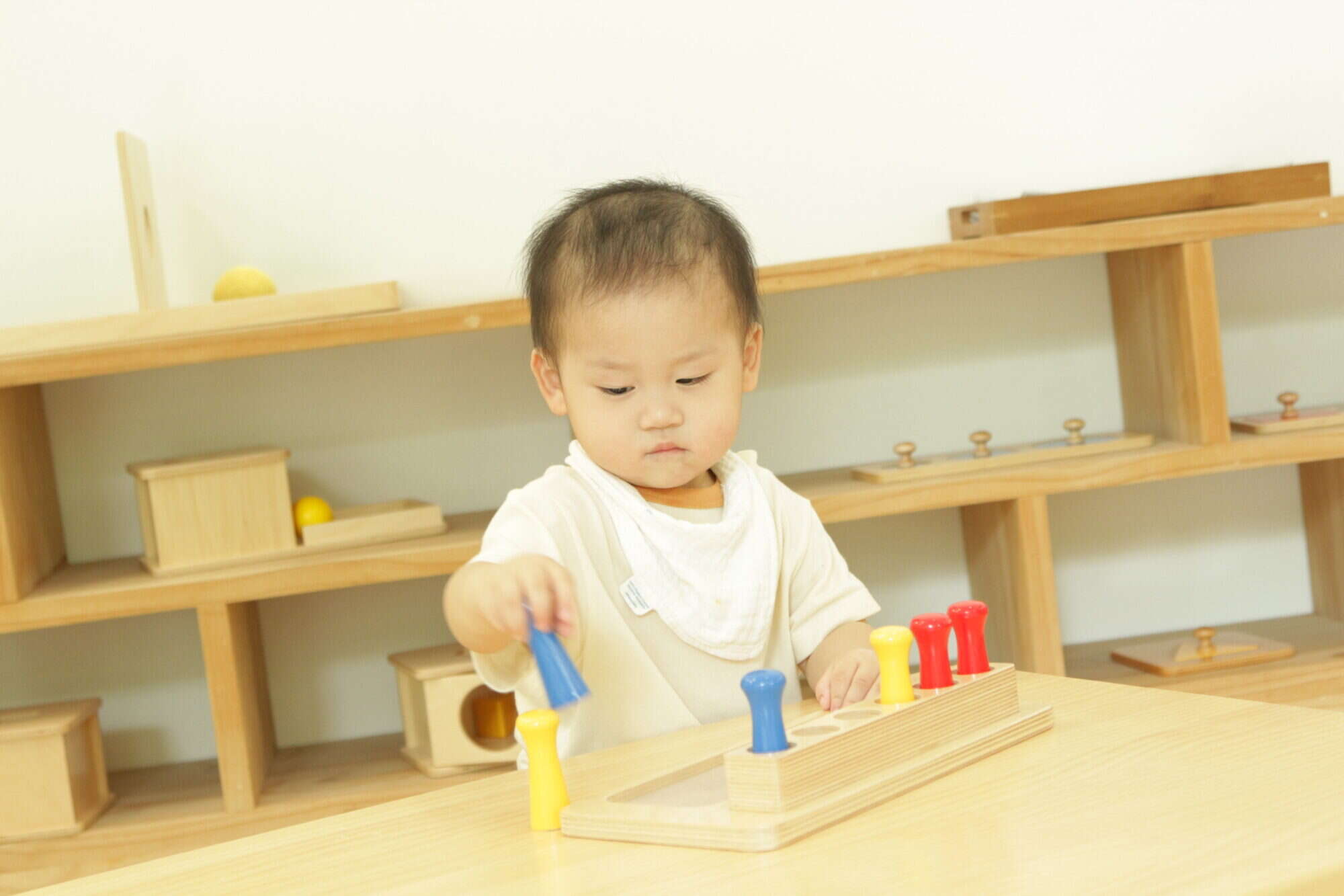 A little boy learning with handcrafted materials in a montessori pre-school